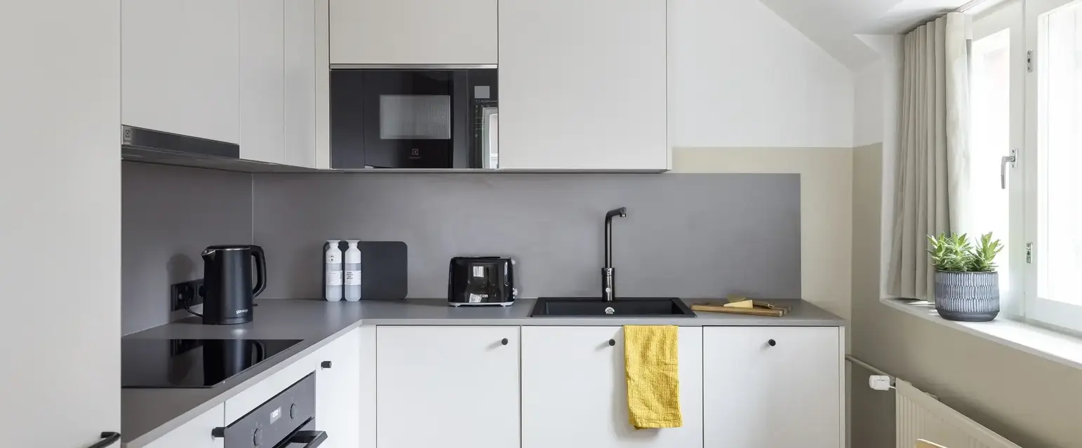 a kitchen with white cabinets and black appliances