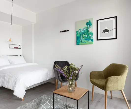 a bedroom with a bed and chairs