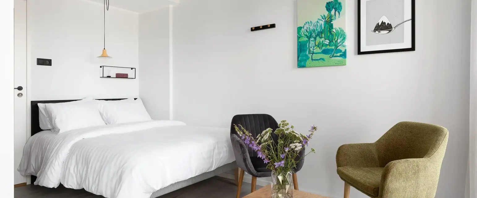 a bedroom with a bed and chairs