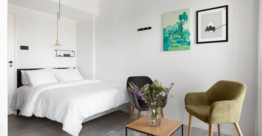 a bedroom with a bed and chairs