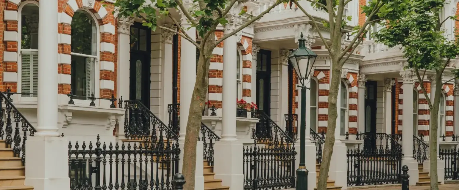 a row of houses with trees and a street light
