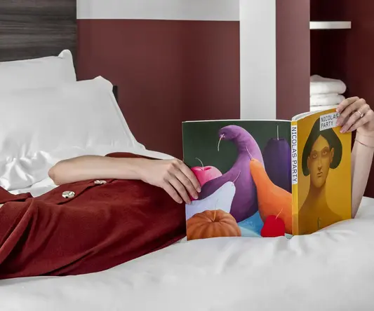 a person lying on a bed reading a book
