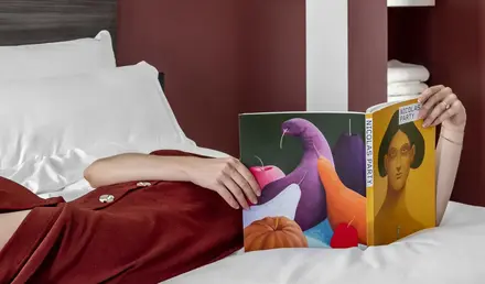 a person lying on a bed reading a book
