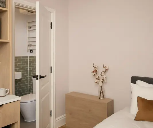 a bedroom with a white bed and a wood dresser