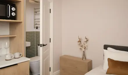 a bedroom with a white bed and a wood dresser