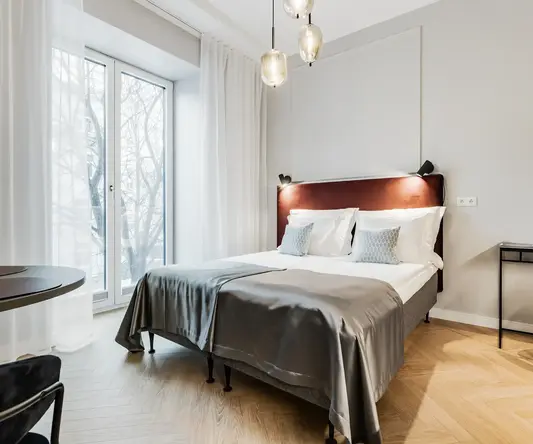 a bed with a headboard and a table with a lamp