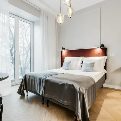 a bed with a headboard and a table with a lamp