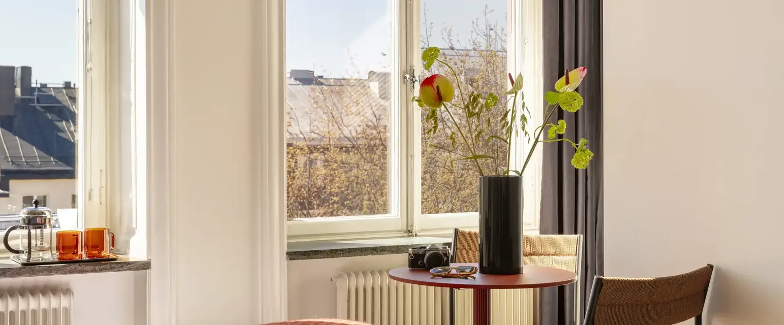 a room with a bed and a vase of flowers