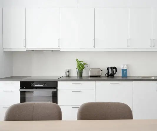 a kitchen with white cabinets and a table