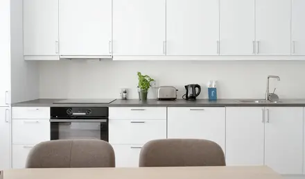 a kitchen with white cabinets and a table