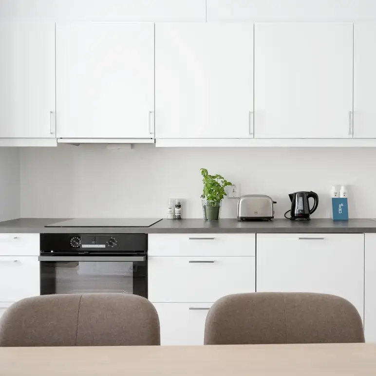 a kitchen with white cabinets and a table