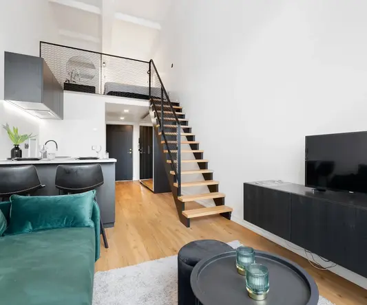 a living room with a tv and stairs