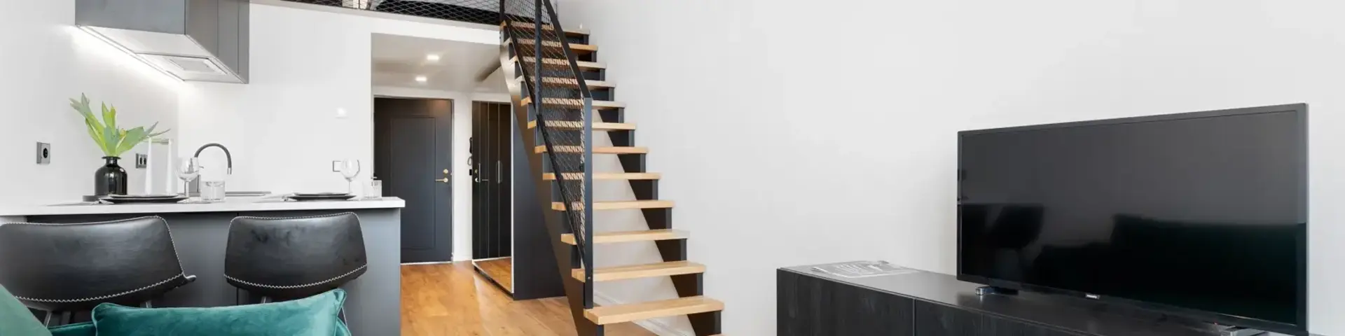 a living room with a tv and stairs
