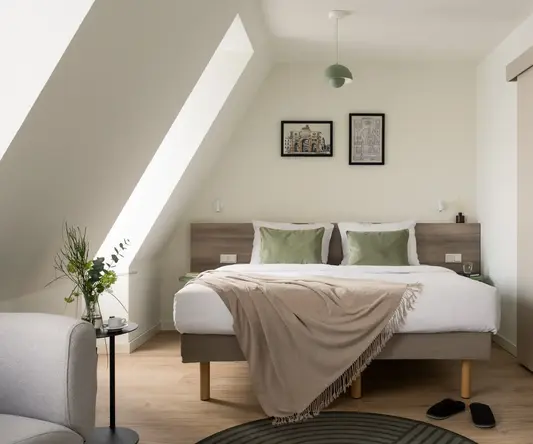 a bed with pillows and a rug in a room