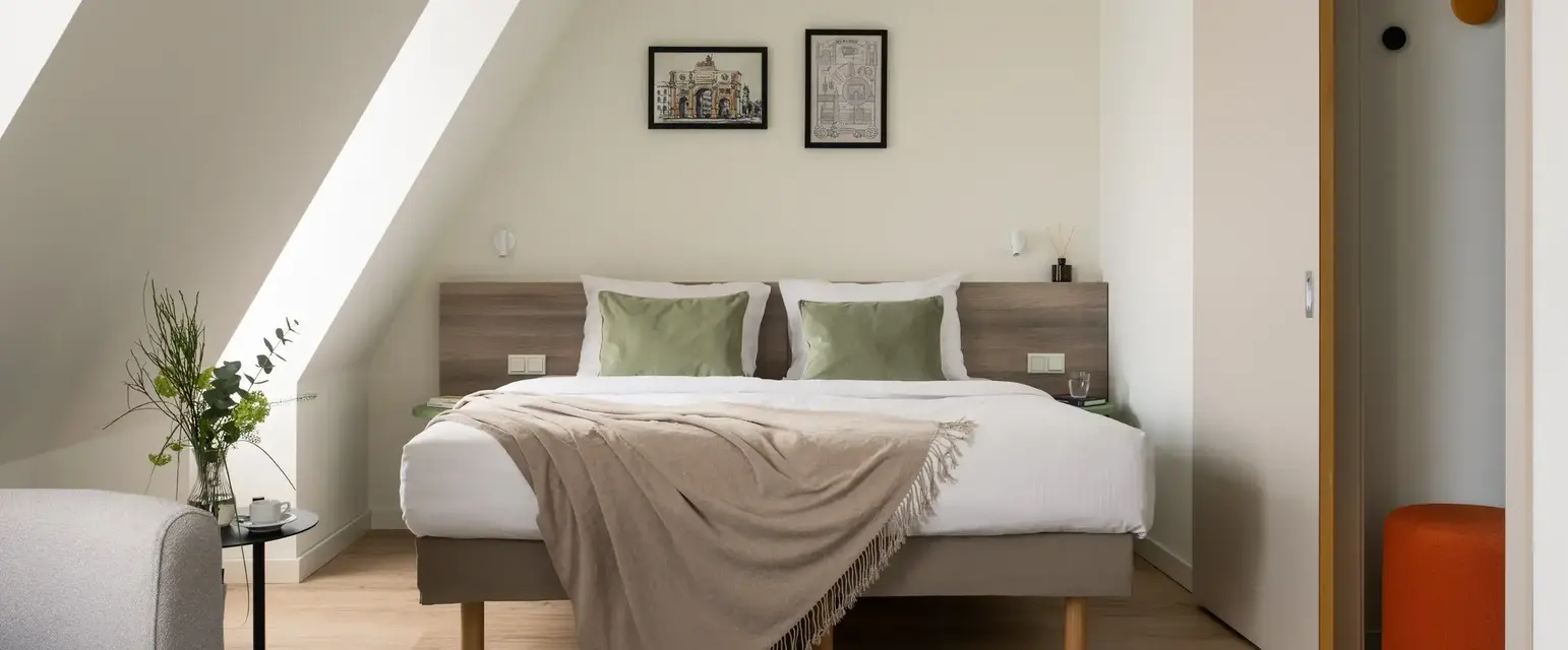 a bed with pillows and a rug in a room