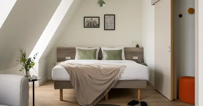 a bed with pillows and a rug in a room