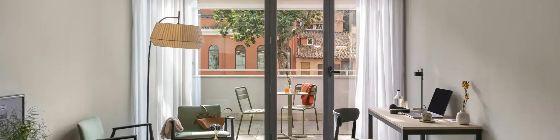 a room with a desk and chairs and a table and a glass door