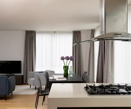 a kitchen and living room with a stove and chairs