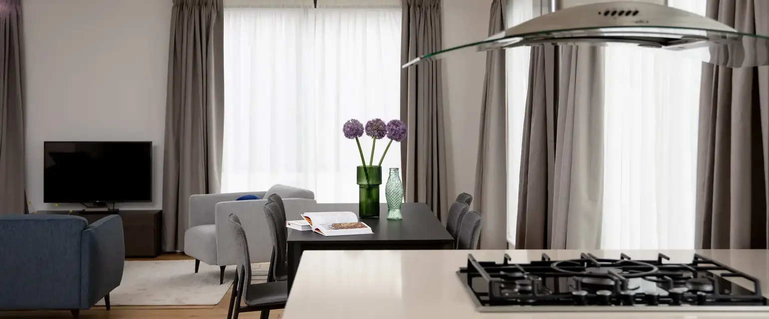 a kitchen and living room with a stove and chairs