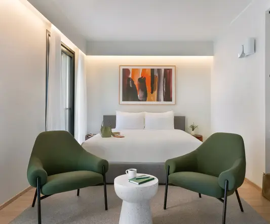 a room with a bed and chairs