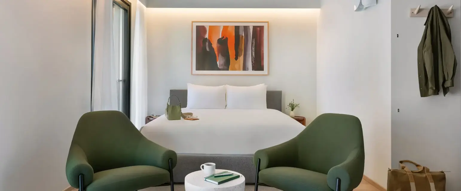 a room with a bed and chairs