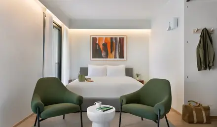 a room with a bed and chairs