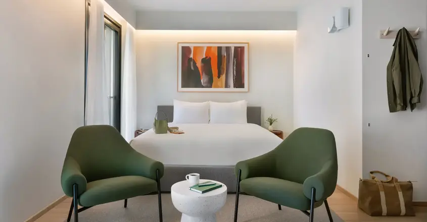 a room with a bed and chairs