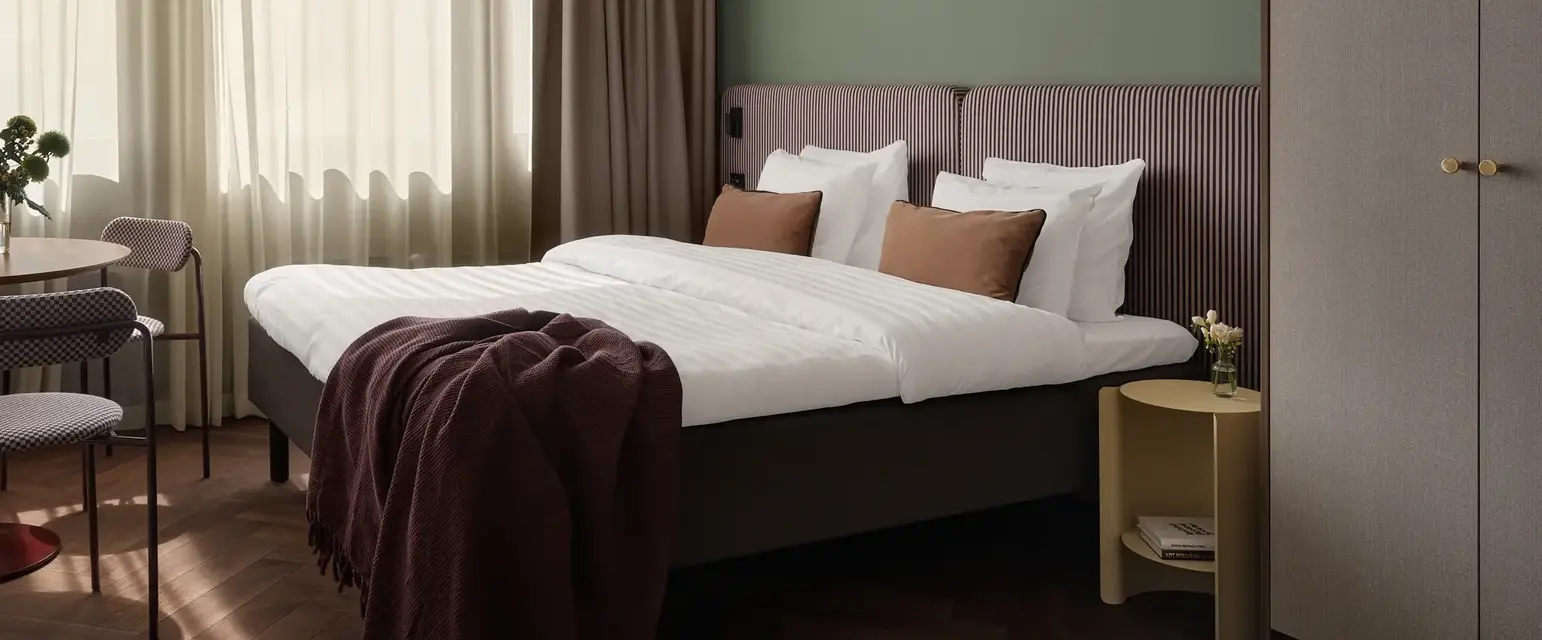 a bed with pillows and a blanket in a room