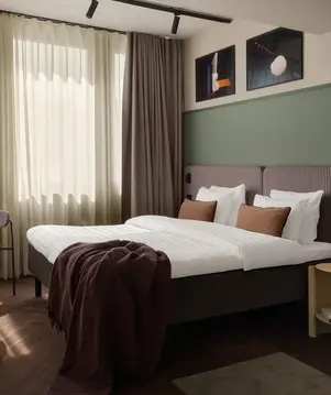 a bed with pillows and a blanket in a room