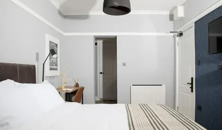 a bed with a striped blanket and a lamp in a room