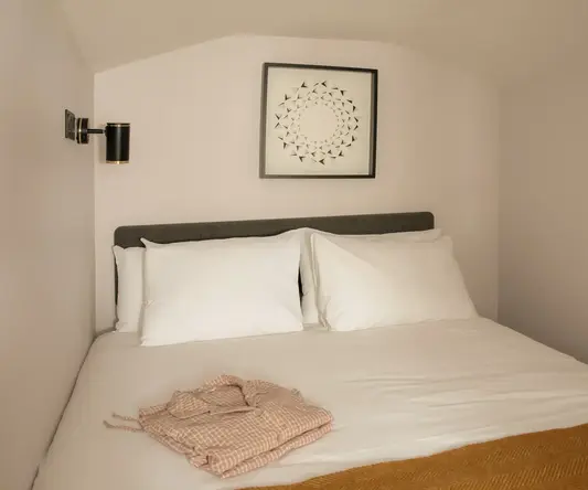 a bed with pillows and a blanket on it