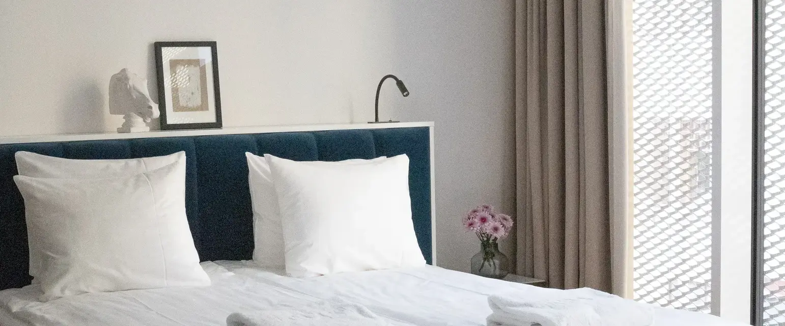 a bed with white sheets and towels