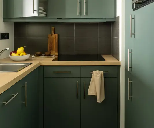 a kitchen with green cabinets and a sink