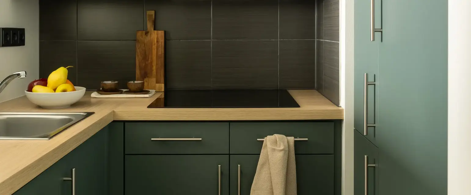 a kitchen with green cabinets and a sink