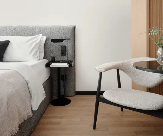 a chair next to a bed