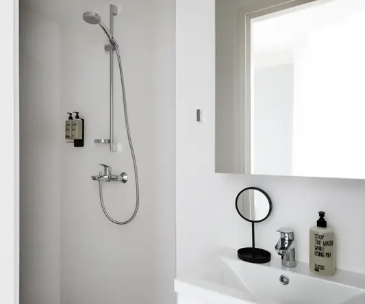 a shower with a round mirror and a sink