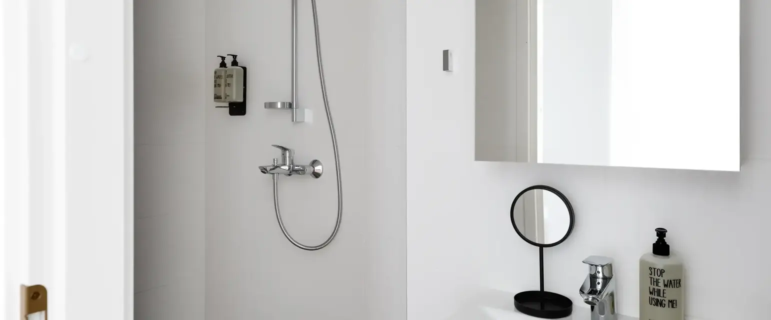 a shower with a round mirror and a sink