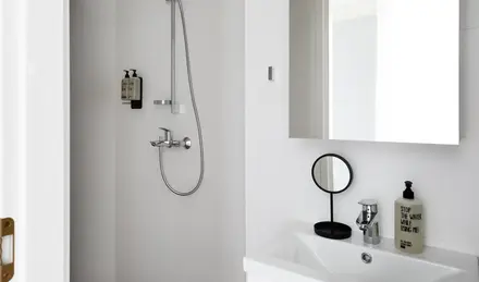 a shower with a round mirror and a sink