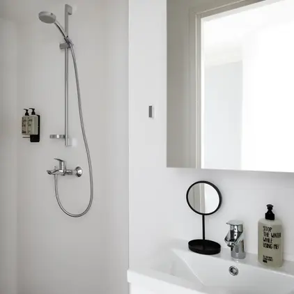 a shower with a round mirror and a sink