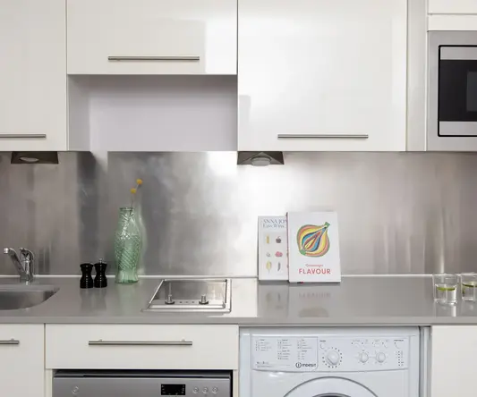 a kitchen with white cabinets and white appliances