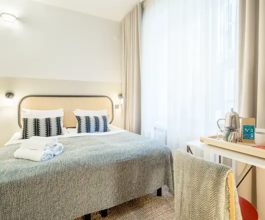 a bed with a table and a coffee pot