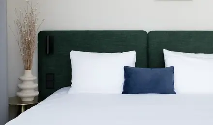 a bed with white sheets and pillows