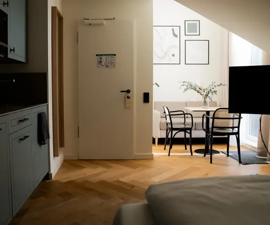 a room with a door and a table and chairs