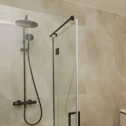 a shower with a glass door and a sink