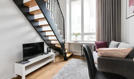 a living room with a staircase and a tv