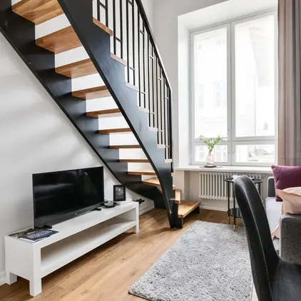 a living room with a staircase and a tv
