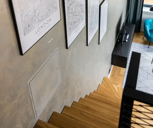 a wall with a picture frame and a blue chair