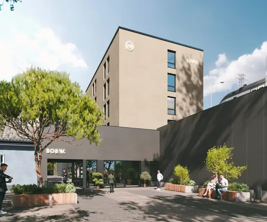 a building with trees and people in front of it