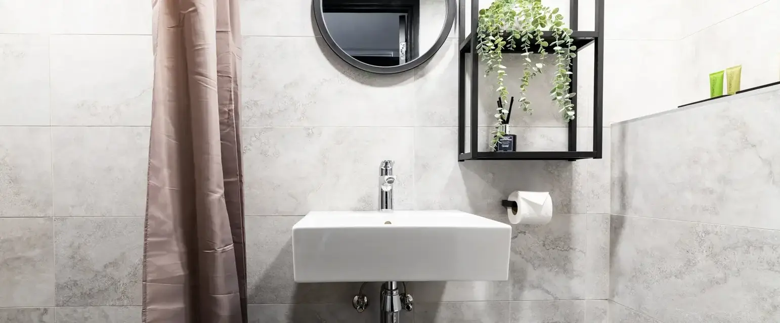 a bathroom with a round mirror and a sink