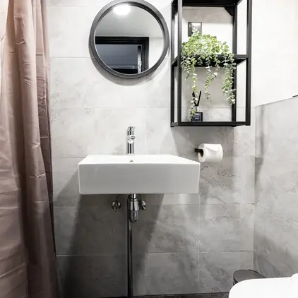 a bathroom with a round mirror and a sink